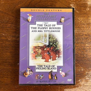May include: A DVD case featuring "The Peter Rabbit Collection" with "The Tale of the Flopsy Bunnies and Mrs. Tittlemouse" and "The Tale of Pigling Bland" by Beatrix Potter. The case has a purple background with illustrations of rabbits and other characters.