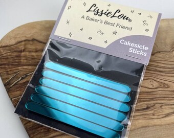 以下が含まれることがあります： ターコイズブルーのケーキシクルスティックのパッケージ。パッケージには、「リジー・ルー」と「A Baker's Best Friend」の文字が書かれています。「ケーキシクルスティック」の文字はパッケージの裏側に書かれています。