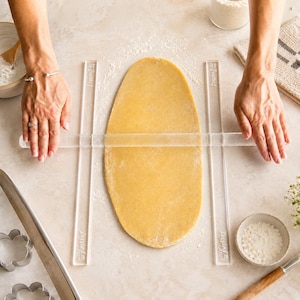 Thickness guides being used with a rolling pin to help get the perfect thickness cookie dough