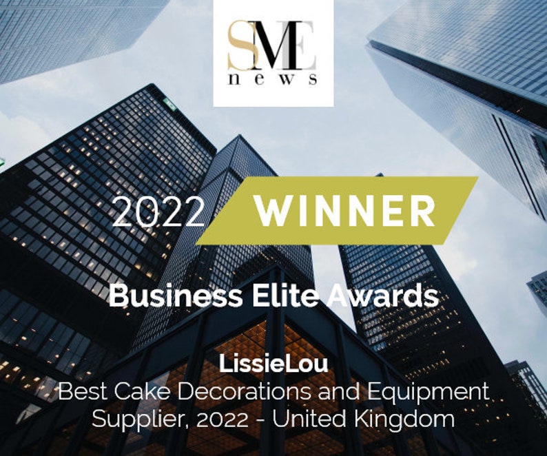 May include: A gold and white award certificate with the text "2022 WINNER Business Elite Awards" and "LissieLou Best Cake Decorations and Equipment Supplier, 2022 - United Kingdom". The certificate is displayed against a backdrop of tall buildings.