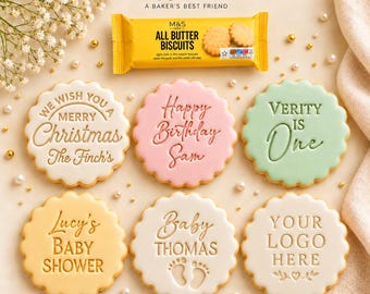 May include: Six round scalloped cookies with embossed text including We Wish You A Merry Christmas The Finch's, Happy Birthday Sam, Verity Is One, Lucy's Baby Shower, Baby Thomas with footprints, and Your Logo Here, plus a pack of M&S biscuits.
