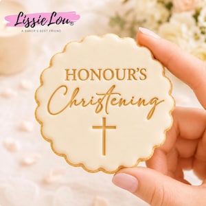 Peut inclure: Un biscuit rond à bords festonnés recouvert d'un glaçage blanc lisse. Le texte HONOUR'S Christening est embossé en doré, accompagné d'une croix dorée simple centrée sous l'inscription. Le biscuit présente un bord cuit brun clair.