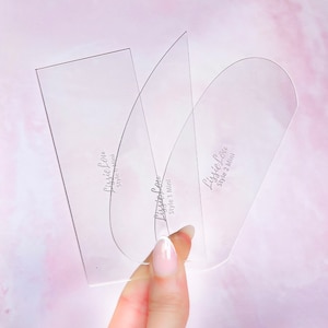 Könnte beinhalten: Drei transparente Kunststoff-Schablonen zum Erstellen verschiedener Augenbrauenformen. Die Schablonen sind mit "LissLove Style 1 Mini" und "LissLove Style 2 Mini" beschriftet.