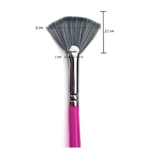 Könnte beinhalten: Ein Fächerpinsel mit rosa Griff, silberner Zwinge und grauen Borsten. Der Pinsel ist 4 cm breit und 2,1 cm hoch. Der Pinsel hat einen Durchmesser von 1 cm an der Zwinge.