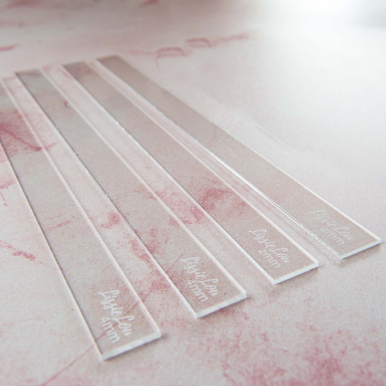 May include: Five clear acrylic rulers with the text "Little Lou 4mm" etched on each one. The rulers are arranged in a staggered pattern.