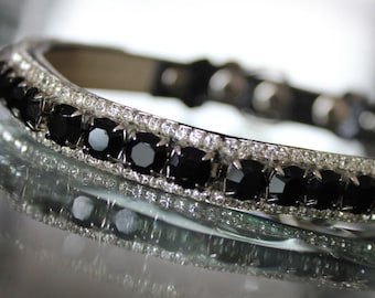 May include: A black and silver pet collar with a row of black rhinestones.