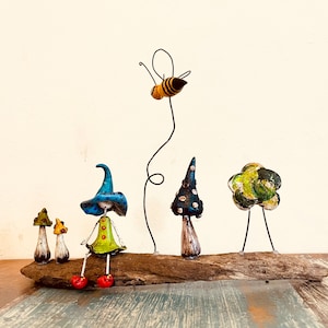 Fee en bij. Feeënsculptuur. Fee in koud porselein. Paddenstoelen. Feeënfiguur met paddenstoelen en een bij. Figuur op natuurlijk hout. Kunst in Barcelona
