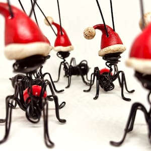 Formica con cappello da Babbo Natale. Formica con cappello di Babbo Natale. Formica di Natale. Regalo di Natale. Decorazione natalizia. Feste