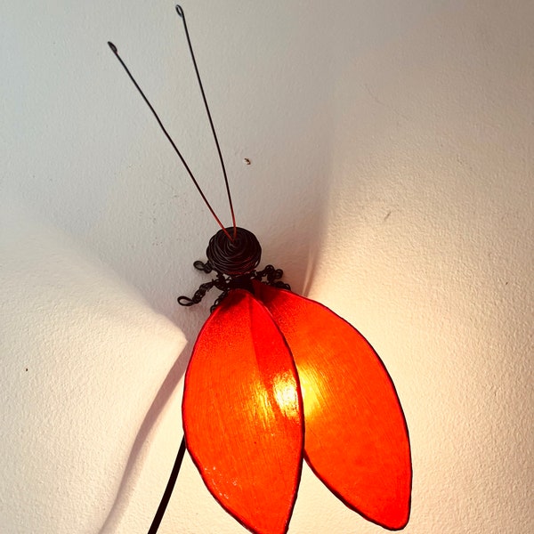 Ameisenförmige Lampe. Rote Lampe. Insektenlampe. Insekt mit Licht. Ameise mit Licht. Ameise mit Flügeln. Fliegen Sie mit Licht. Libelle.