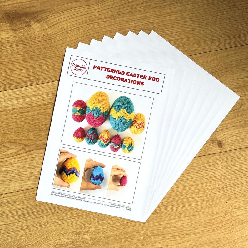 May include: A stack of printed instruction sheets titled Patterned Easter Egg Decorations by Womble Knits. The pages feature photographs of small, hand-knitted, multi-coloured egg-shaped ornaments in yellow, blue, pink, and purple patterns.