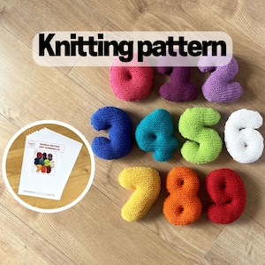 Puede incluir: Un conjunto de números tejidos de cero a nueve en una variedad de colores brillantes, incluyendo rosa, morado, azul, verde, amarillo, naranja y rojo. Las palabras "Knitting pattern" se muestran encima de los números. También se incluye un patrón.