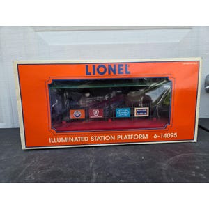 May include: Lionel illuminated station platform model in its original box. The box is orange with the Lionel logo and the words "Illuminated Station Platform". The platform has several signs and is visible through a clear plastic window.