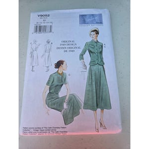 May include: A Vogue Patterns sewing pattern envelope V9052 for an original 1949 design. The white paper envelope features illustrations of a green two-piece suit and a green dress with a belt. Text includes V9052, size B5, and Vogue Vintage Model.