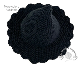 May include: Black crocheted witch hat with a scalloped brim.  The hat is made with a textured stitch and has a pointed crown.
