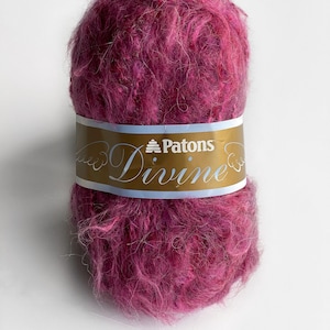 May include: A ball of Patons Divine yarn in a deep pink color. The yarn is a fuzzy, mohair blend.