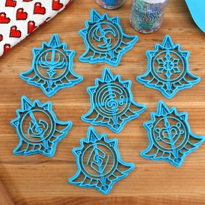 May include: Set of seven blue plastic cookie cutters shaped like different designs with a sunburst pattern around the edges.
