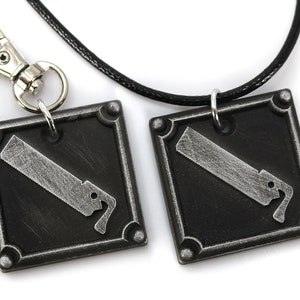 May include: A black leather cord necklace with a silver square pendant featuring a saw blade design. A matching silver keychain with a saw blade design is also included.
