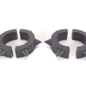 May include: Two grey plastic rings with spikes, each ring is split into two pieces.