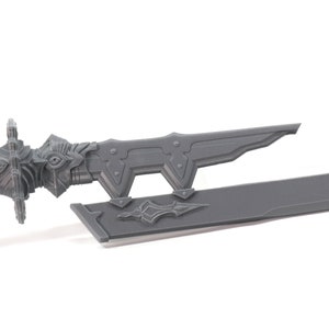 May include: A grey plastic sword with a detailed handle and a sharp blade. The sword is lying on a white surface.