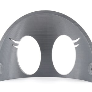 May include: A gray plastic 3D printed mask with two oval eye holes and a curved top. The mask has a textured surface and two small holes on the sides.