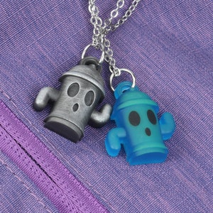 May include: Two silver and blue fire hydrant charms on a silver chain. The charms are shaped like fire hydrants with a cartoon face and arms.