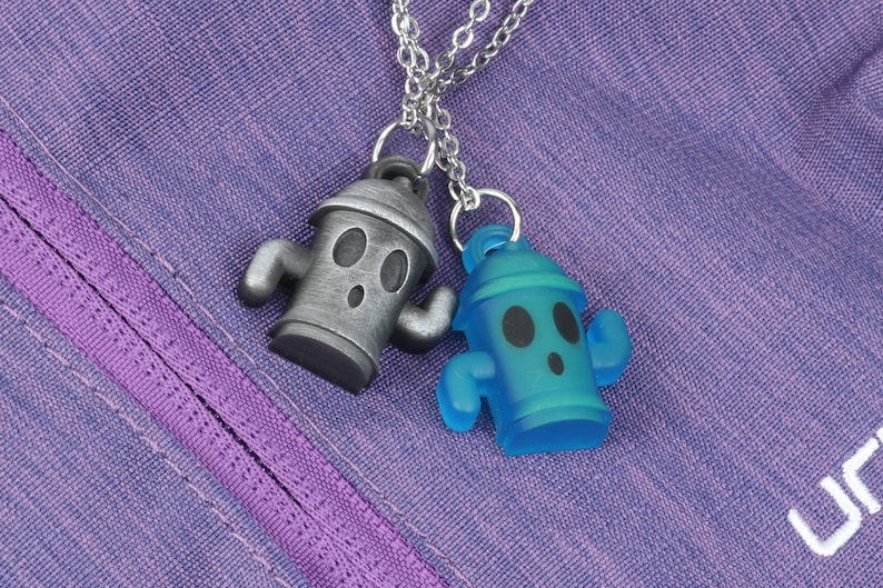 May include: Two silver and blue fire hydrant charms on a silver chain. The charms are shaped like fire hydrants with a cartoon face and arms.