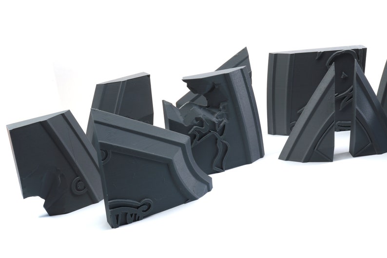 May include: A set of six gray, geometric, 3D printed puzzle pieces. The pieces are designed to fit together to form a larger shape.