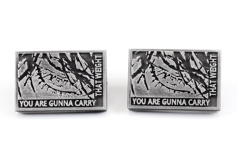 May include: Two silver pins featuring a black and white image of a tree branch and the text "You are gonna carry that weight" on each pin.