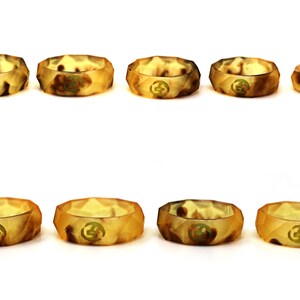 May include: Eight silicone rings in a variety of brown and tan camouflage patterns. The rings are all the same size and shape, and they have a raised design on the top.