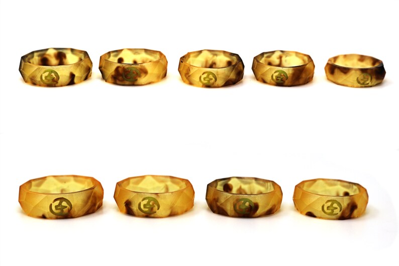 May include: Eight silicone rings in a variety of brown and tan camouflage patterns. The rings are all the same size and shape, and they have a raised design on the top.