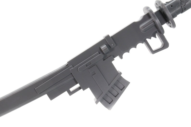 Puede incluir: Una pistola de juguete de pl&aacute;stico gris con una culata plegable y un cargador. La pistola tiene un dise&ntilde;o futurista con una empu&ntilde;adura dentada y una superficie texturizada.