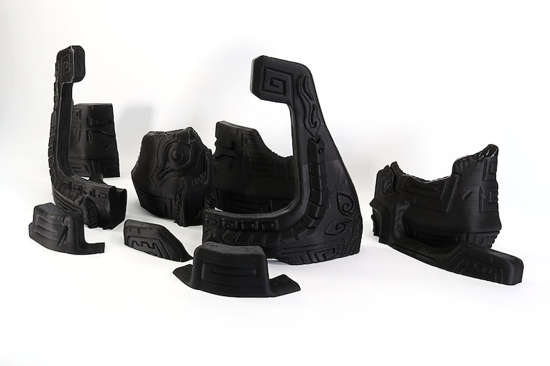 以下が含まれることがあります： 黒色の3Dプリントされたパーツのセットで、組み立てるとボートのモデルになります。パーツは複雑な彫刻とパターンで装飾されています。