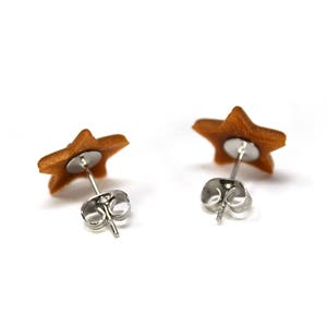 May include: A pair of gold star-shaped earrings with silver posts and backs.