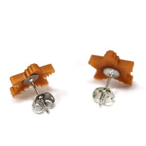 May include: A pair of gold-colored star-shaped earrings with silver post and butterfly backs.