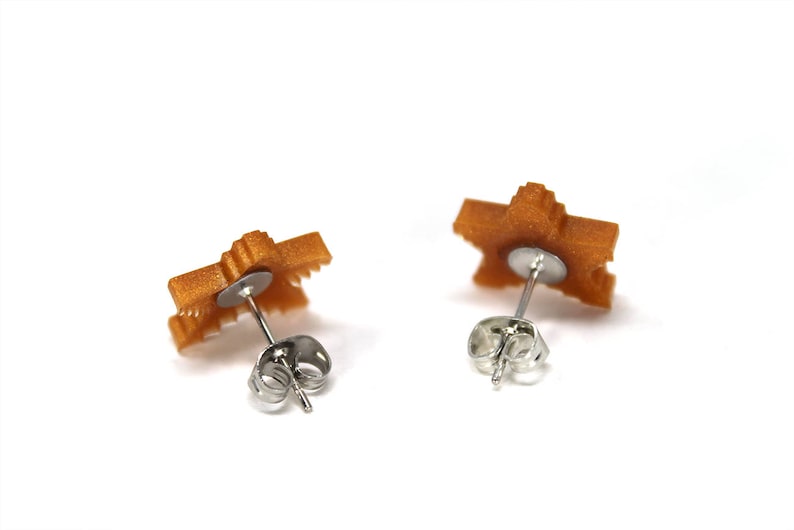 May include: A pair of gold-colored star-shaped earrings with silver post and butterfly backs.