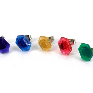 May include: Five colorful, octagonal-shaped earrings with silver posts. The earrings are blue, gold, red, green, and purple.