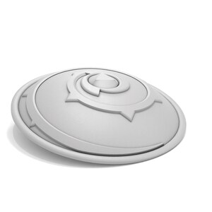 Puede incluir: Un objeto decorativo blanco circular con un dise&ntilde;o geom&eacute;trico conc&eacute;ntrico en relieve. El objeto tiene un acabado liso y brillante.