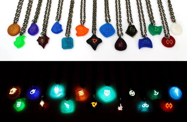 May include: A set of 16 glow-in-the-dark necklaces with different colored pendants featuring various symbols. The necklaces are displayed in two rows, with the top row showing the pendants in daylight and the bottom row showing the pendants glowing in the dark.