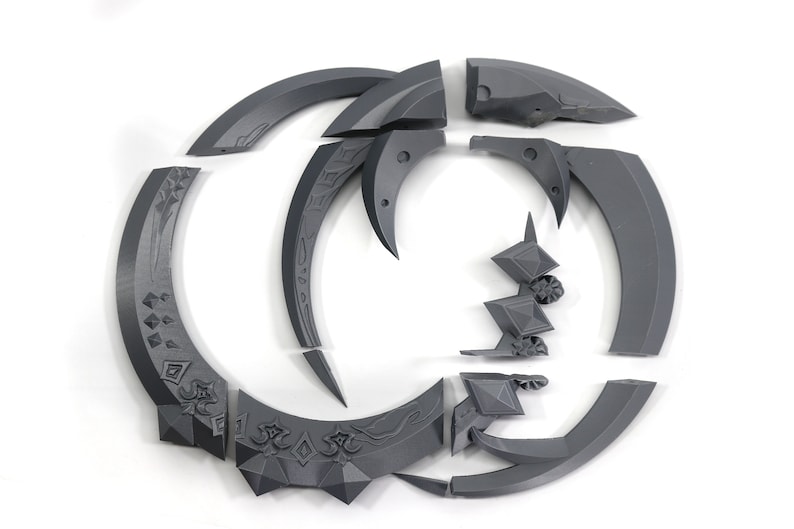 May include: A set of 10 gray 3D printed pieces that form a circular design. The pieces are intricate and detailed, with a variety of shapes and patterns.
