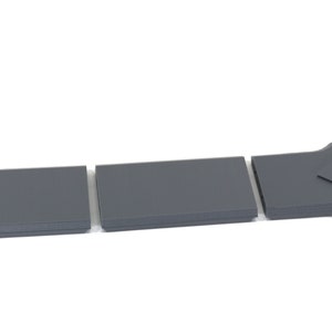 Puede incluir: Tres piezas de pl&aacute;stico gris que se pueden ensamblar para formar una espada. La espada tiene un dise&ntilde;o triangular en el mango.