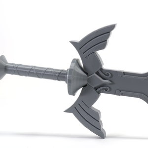 Puede incluir: Una r&eacute;plica de pl&aacute;stico gris de la Espada Maestra de la serie de videojuegos The Legend of Zelda. La espada tiene una empu&ntilde;adura detallada y una hoja triangular con el s&iacute;mbolo de la Trifuerza.