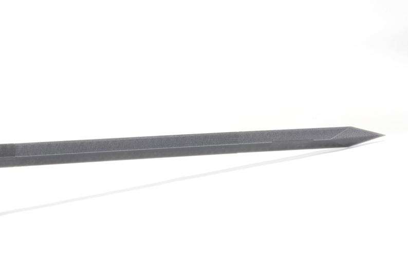 May include: A close-up of a long, thin, silver-coloured metal rod with a pointed tip.