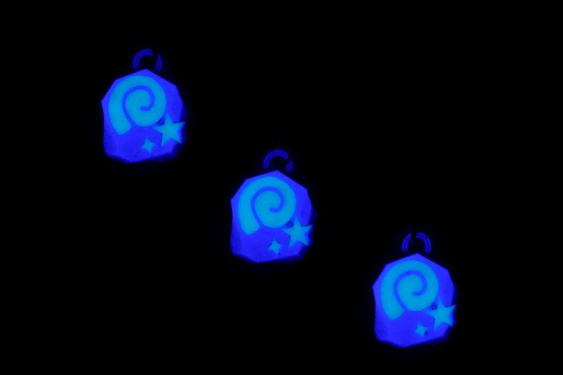 May include: Three blue glow-in-the-dark charms with a spiral and star design.