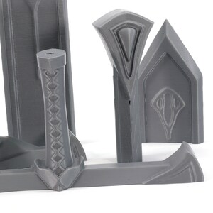 May include: A set of gray plastic sword parts for a 3D printed model. The parts include the blade, hilt, and pommel.
