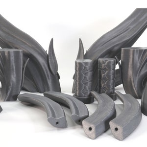 May include: A set of 3D printed black plastic pieces, some with a textured surface, resembling a stylized tree branch or a set of abstract sculptures.