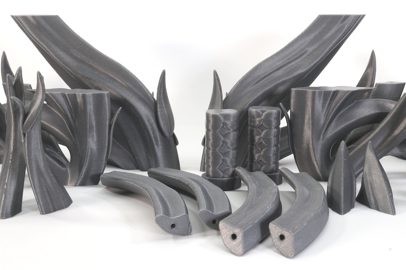 May include: A set of 3D printed black plastic pieces, some with a textured surface, resembling a stylized tree branch or a set of abstract sculptures.
