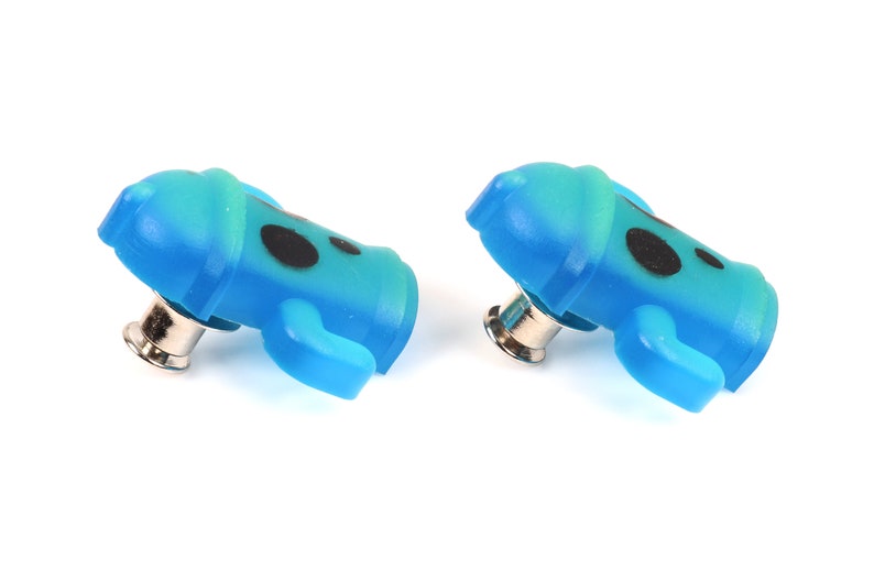 May include: Two blue and green plastic buttons with black dots and a silver pin on the back.