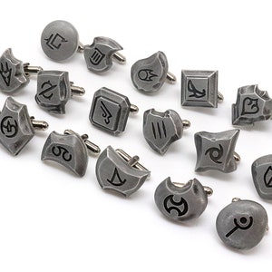 May include: A set of 18 silver cufflinks with different symbols, including a crescent moon, a star, a shield, and a sword.