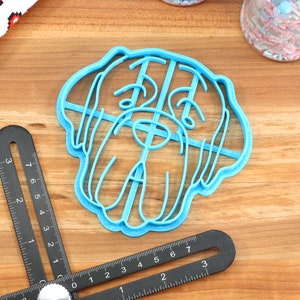 Peut inclure: Emporte-pi&egrave;ce en plastique bleu en forme de t&ecirc;te de chien. L'emporte-pi&egrave;ce a un design d&eacute;taill&eacute; avec des lignes et des courbes.
