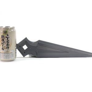 May include: A gray 3D printed sword-like object next to a can of Japanese beer. The can has Japanese text that reads "二代目  麦酒" and "麦酒ビール".